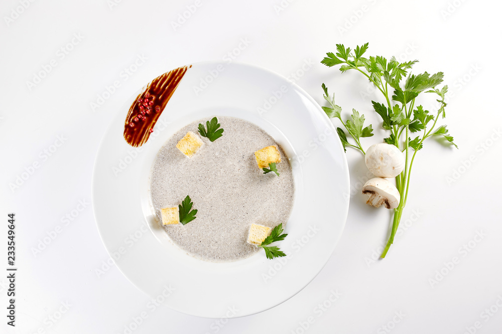 Mushroom cream soup with croutons, herbs and spices over white background close up - homemade vegan vegetarian diet organic meal food soup