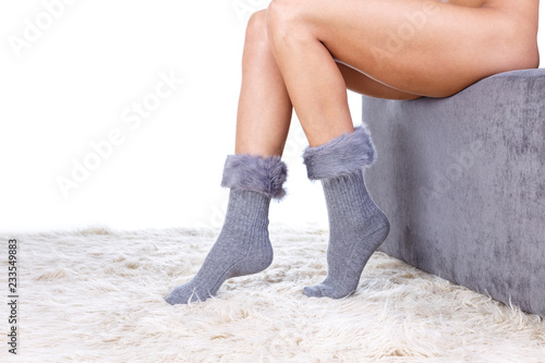 Beautiful wool socks with fur trimming for slender tanned legs of a young girl photo