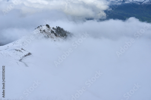 Clouds in the mountain valley with peaks above. Jungfrau region in Switzerland. photo