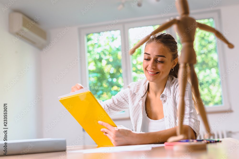 Woman sitting desk and drawing in her apartment.learning to draw concept. Woman sitting desk and drawing in her apartment.learning to draw concept.