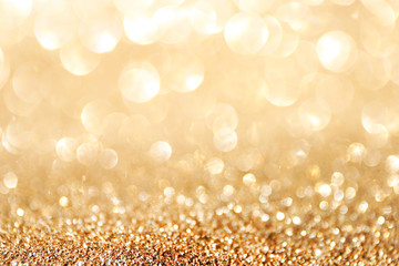 Golden sparkle glitters with bokeh effect and selectieve focus. Festive background with bright gold lights, champagne bubble. Christmas mood concept. Copy space, close up, texture, top view.