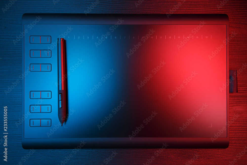 Graphic tablet with pen for illustrators and designers on black wooden background. Graphic tablet with pen for illustrators and designers on black wooden background.