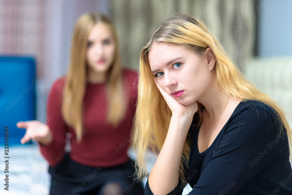 The concept a couple of beautiful young lesbian girls are talking in a room sitting on a sofa. The concept a couple of beautiful young lesbian girls are talking in a room sitting on a sofa.