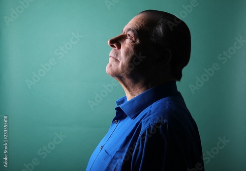 Beautiful older man in front of a colored background