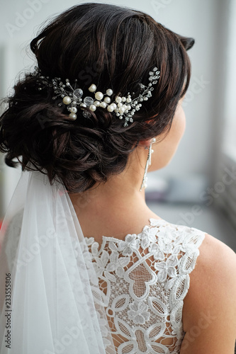 closeup of a hair clip of beads and pearls in the hair of the bride. wedding hairstyle, morning of the bride