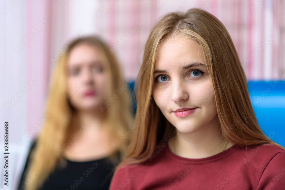 The concept a couple of beautiful young lesbian girls are talking in a room sitting on a sofa. The concept a couple of beautiful young lesbian girls are talking in a room sitting on a sofa.