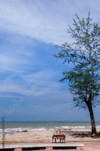 Songkhla  Thailand - Tourist couple sit on bench at Samila Beach in summer