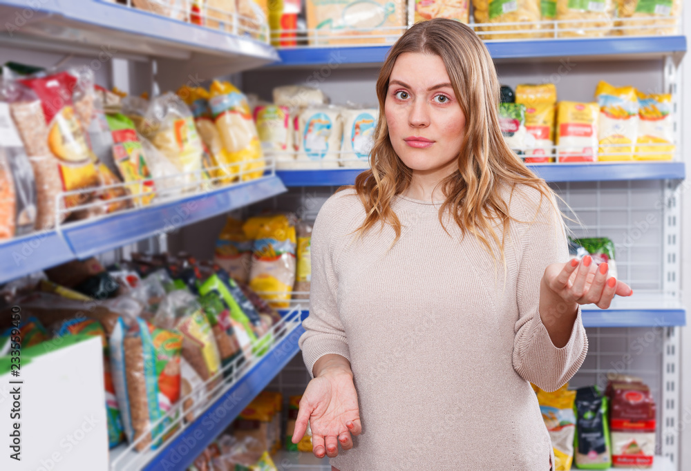 Woman buyer standing near assortment of grocery food store