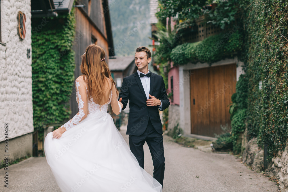 A beautiful wedding couple walks in a fairy Austrian town, Hallstatt. A beautiful wedding couple walks in a fairy Austrian town, Hallstatt.