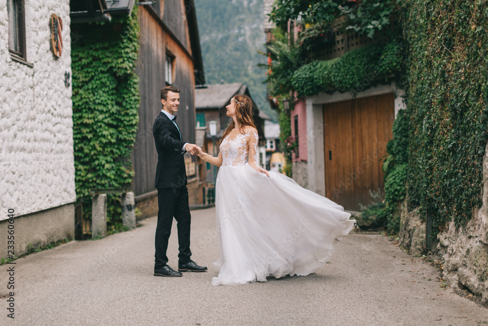 A beautiful wedding couple walks in a fairy Austrian town, Hallstatt. A beautiful wedding couple walks in a fairy Austrian town, Hallstatt.