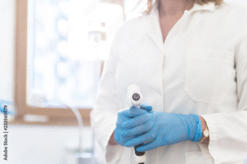 Woman doctor with a fractional mesotherapy gun in hands Woman doctor with a fractional mesotherapy gun in hands