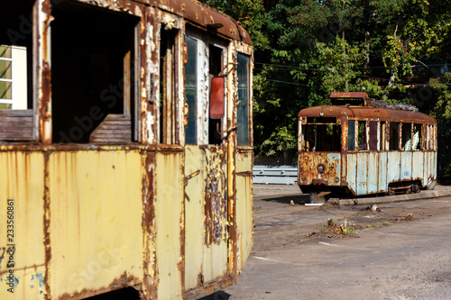 Old rusty destroyed trams outdoors at sunny day.