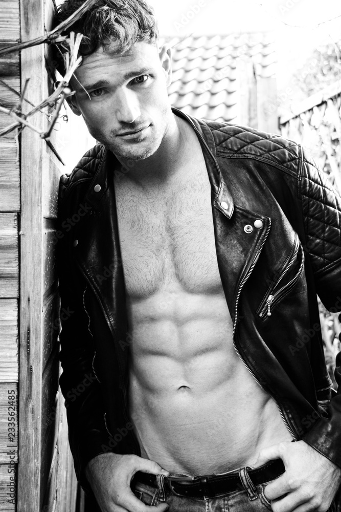 Handsome blonde man with open leather jacket revealing sixpack abs and ...