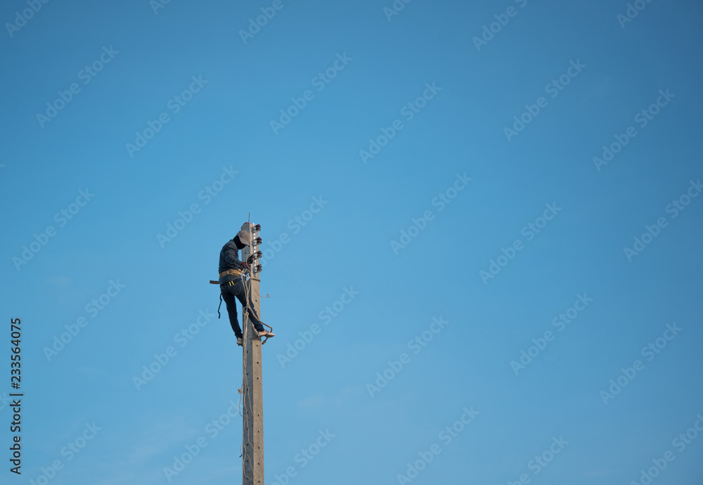 Electrician climbing electric pole