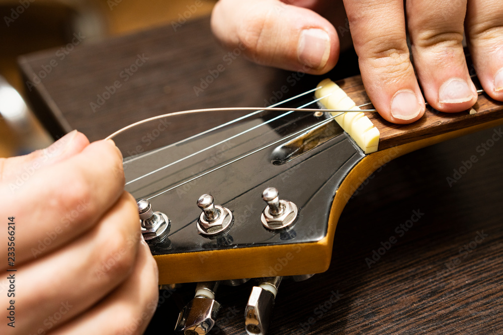 Installation strings of electric guitar through upper threshold on the