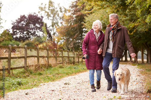 Active Senior Couple On Autumn Walk With Dog On Path Through Countryside © Monkey Business