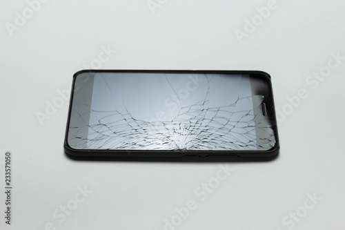 Mobile smartphone with broken screen on white background