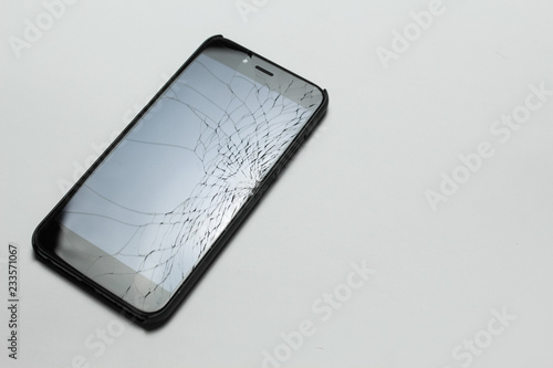 Mobile smartphone with broken screen on white background