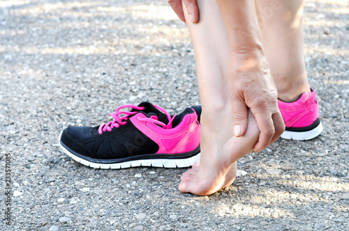 Pain in the foot.Running injury leg accident- sport woman runner hurting massaging painful sprained ankle in pain.Athlete woman has heel injury, sprained ankle during running training.
