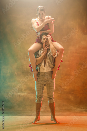 Flexible young modern couple dancing tango in studio. Fashion portrait of attractive dancing couple. Man and woman. Passion. Love. perfect skin facial and make-up. Human emotions - love and passion