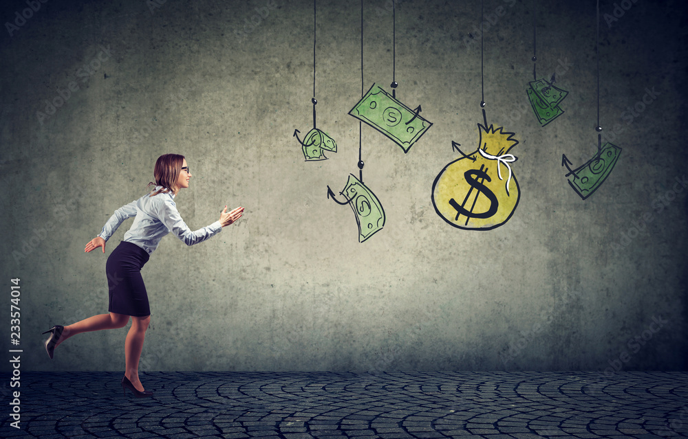 Business woman motivated by money hanging on a fishing hook. Stock Photo