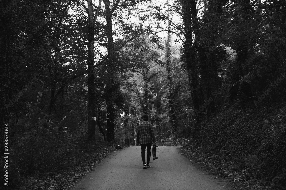 Man walking in the road in the autumn forest of Canada Man walking in the road in the autumn forest of Canada