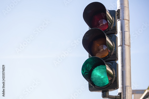 Green traffic lights for cars, blue sky background photo