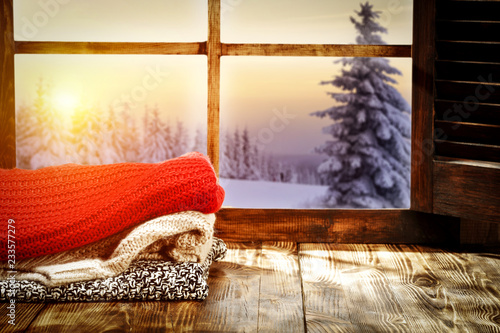Winter window and start wooden table with warm cloths   