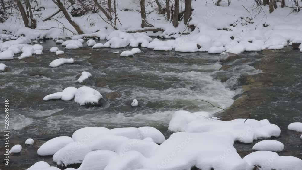 Snowy river. Snow on rocks and on forest riverbank. Don River, Toronto, Ontario, Canada. Snowy river. Snow on rocks and on forest riverbank. Don River, Toronto, Ontario, Canada.