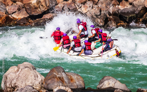 Young persons rafting on the river Ganges in Rishikesh, extreme and fun sport at tourist attraction photo