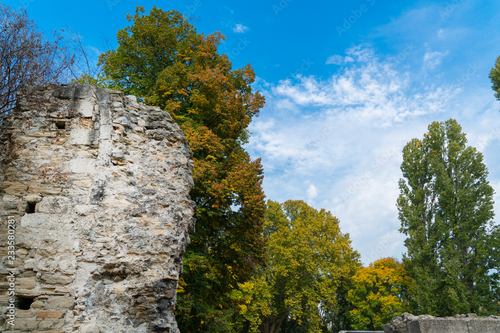 Part of castle wall at Margaret Island at Budapest / Hungary and trees with blue and cloudy sky background