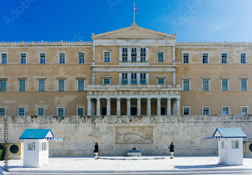Фотография Athens, Greece — November 11, 2018: Evzones or Evzonoi guarding the Tomb of the Unknown Soldier at the Hellenic Parliament building (the Old Royal Palace) on Syntagma Square in Athens, Greece
