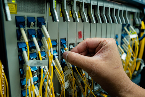 a hand of engineer is plugging fiber cable into the network devices for check optical power