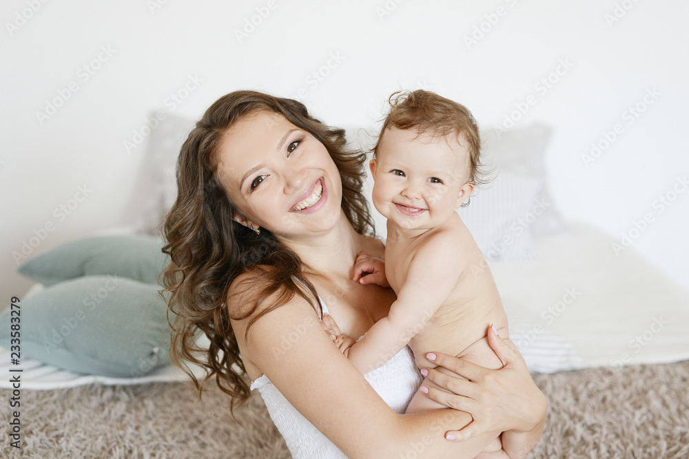 Happy mother hugging her adorable little daughter, greeting card for Mothers Day. Women's Day. March 8. Spring greetings. Happy family at home. Healthy family concept, mom and baby daughter.
