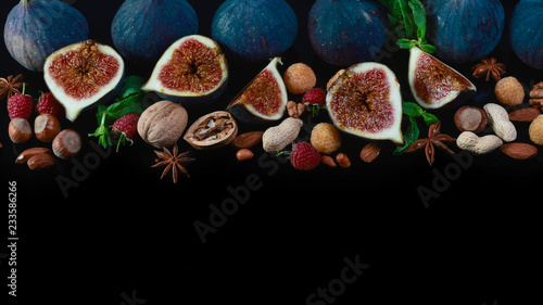 Frame of various fruits and nuts: figs, isolated on black background. Top view. copy space