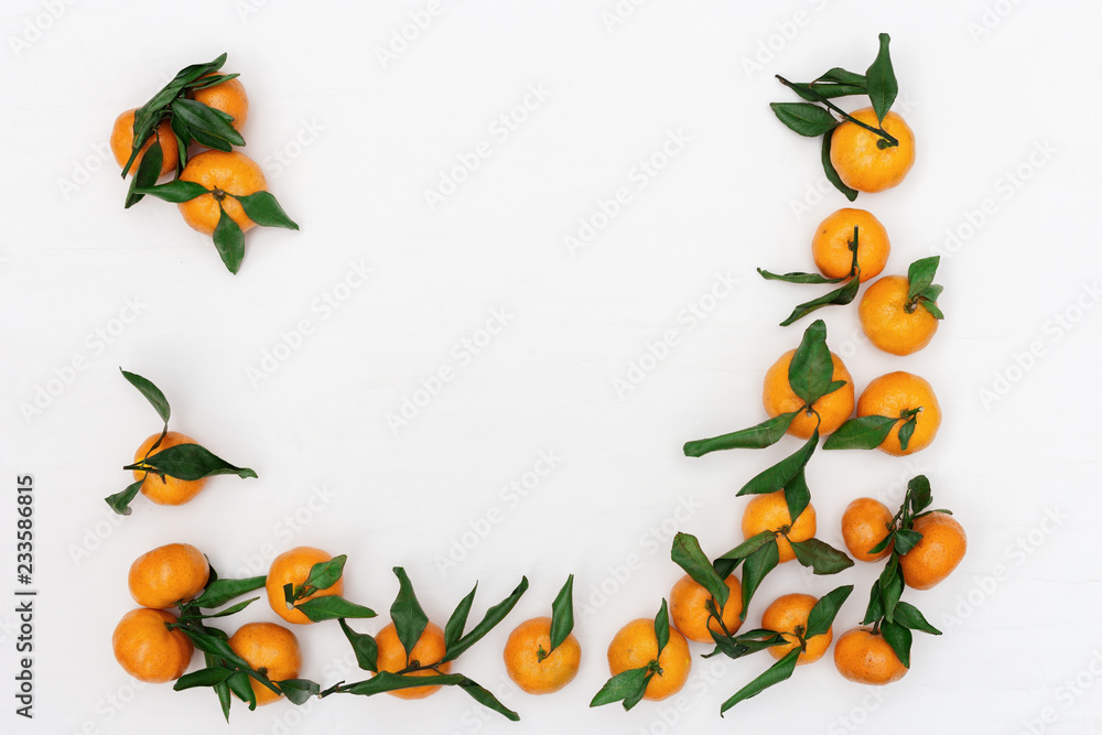 Fototapeta premium Fresh citrus fruits tangerine or mandarin on white background. Flat lay. Copy space. Frame from bright tasty tangerines.