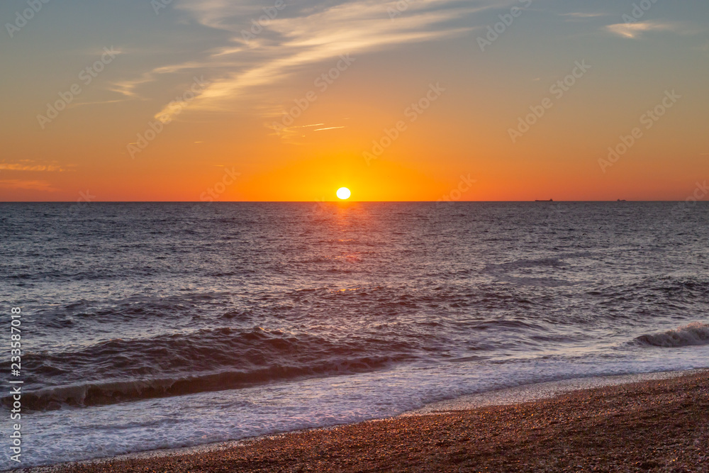 The sun setting over the sea at Brighton Beach