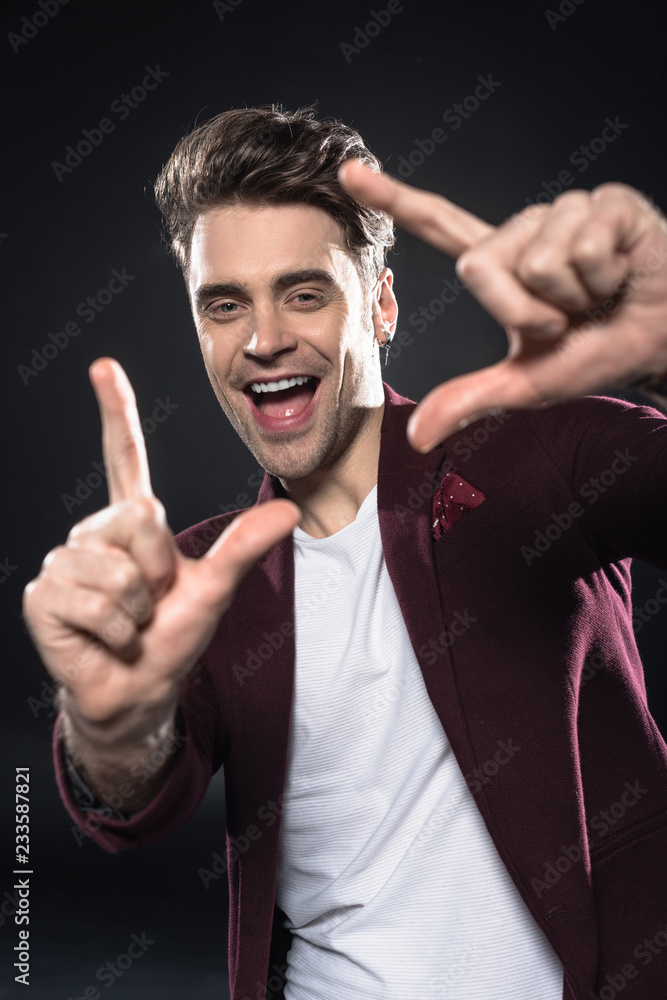 close-up shot of happy young man showing frame gesture isolated on black close-up shot of happy young man showing frame gesture isolated on black