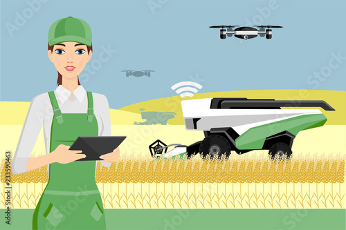 Woman farmer controls an autonomous combine harvester and drone. Internet of things in agriculture
