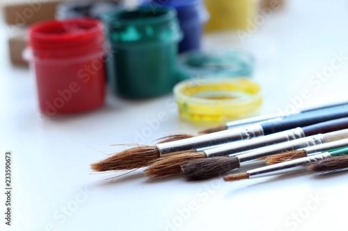 Colored paints with brushes on a white background