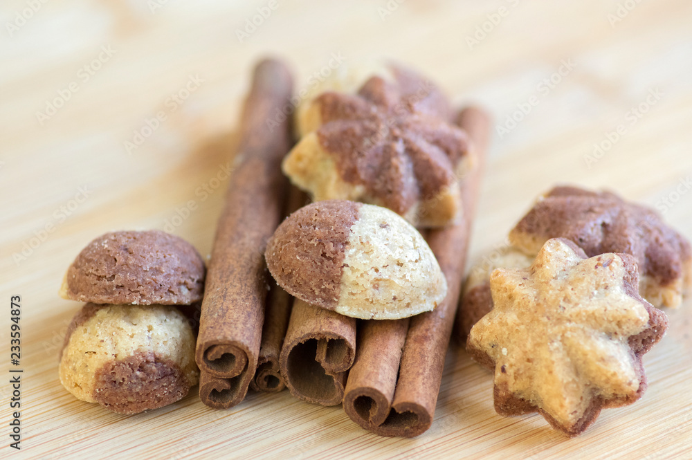 Fototapeta premium Cinnamon sandbakelse christmas cookies, two colors, cocoa dark brown and vanilla light golden brown, cinnamon raw bark spice