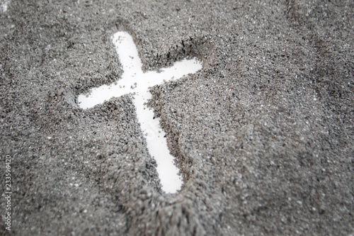 Christian cross or crucifix drawing in ash, dust or sand as symbol of religion, sacrifice, redemtion, Jesus Christ, ash wednesday, Ash Wednesday concept photo