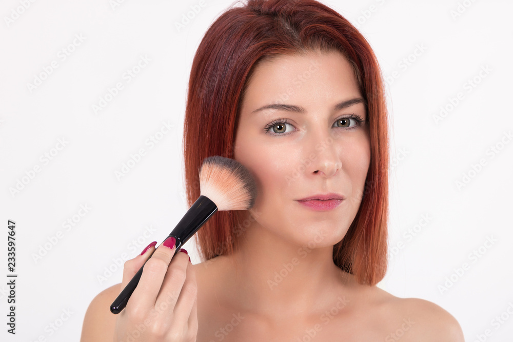 Beautiful woman applying blush with make up brush. Beautiful woman applying blush with make up brush.