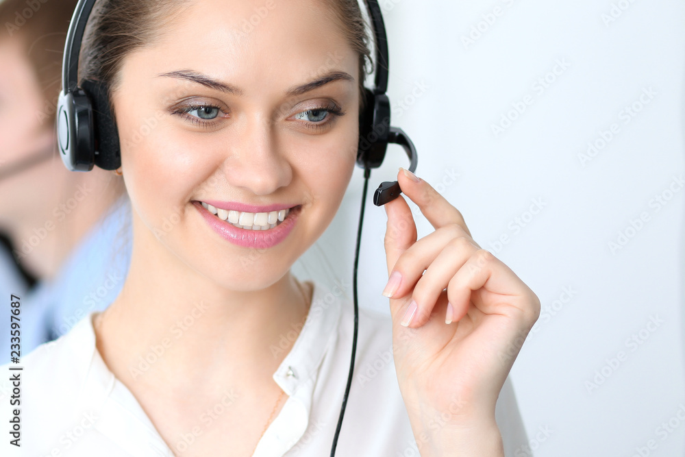 Call center operators at work. Focus at business woman in headset Call center operators at work. Focus at business woman in headset