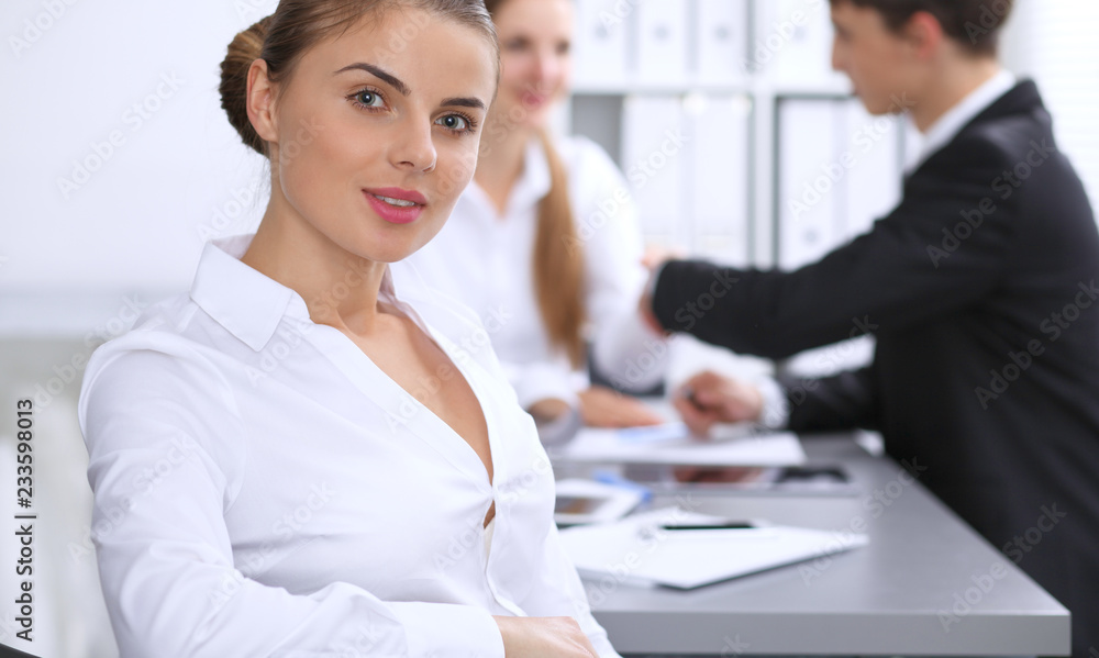 Fototapeta premium Group of business people at meeting on the background of office. Focus at a beautiful brunette woman