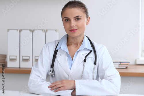 Doctor woman writing papers at the desk in hospital office. Medicine and over work concept