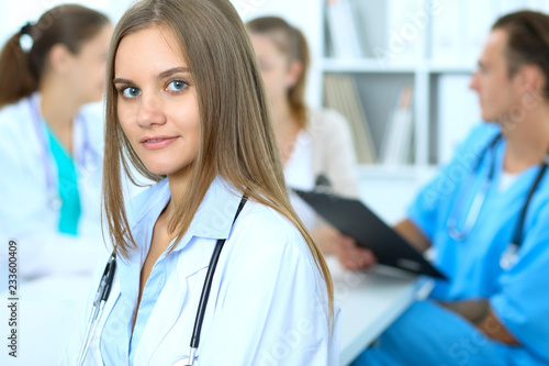 Happy doctor woman with medical staff at the background in hospital office