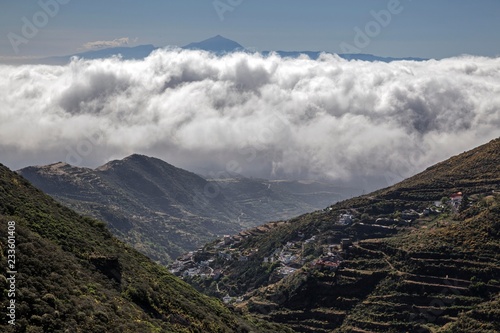 View in the Barranco Hondo de Abajo, at Juncalillo, trade wind clouds and Tenerife island with volcano Teide, Gran Canaria, Canary Islands, Spain, Europe photo