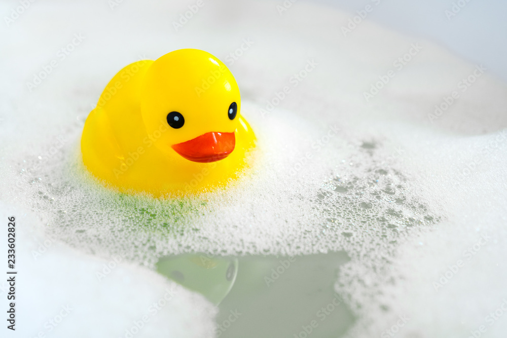One yellow rubber duck with soap bubble bath, light  background with bubbles. Kids spa concept. Children`s bath time concept. - obrazy, fototapety, plakaty 