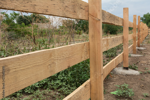 Ranch style fence. Rural wooden fence on green grass at farm ranch land in Shagany, Ukraina.